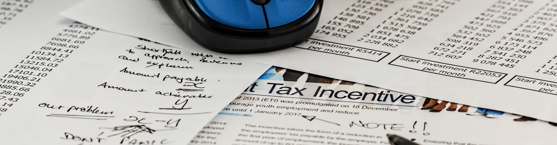 Keyboard, mouse, and tax documents with numbers, symbolizing the process of filing ERC refund lawsuits.