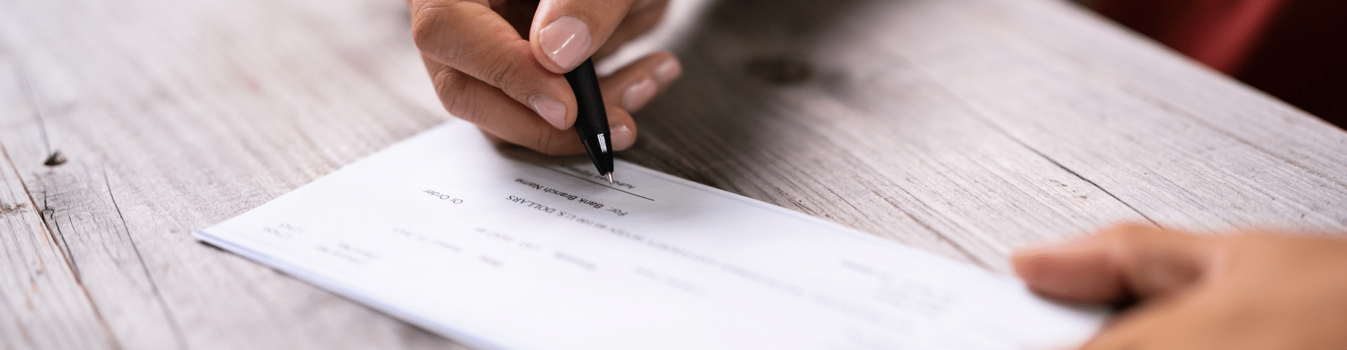 Business owner signing a check, signaling the receipt of their ERC refund check from the IRS.